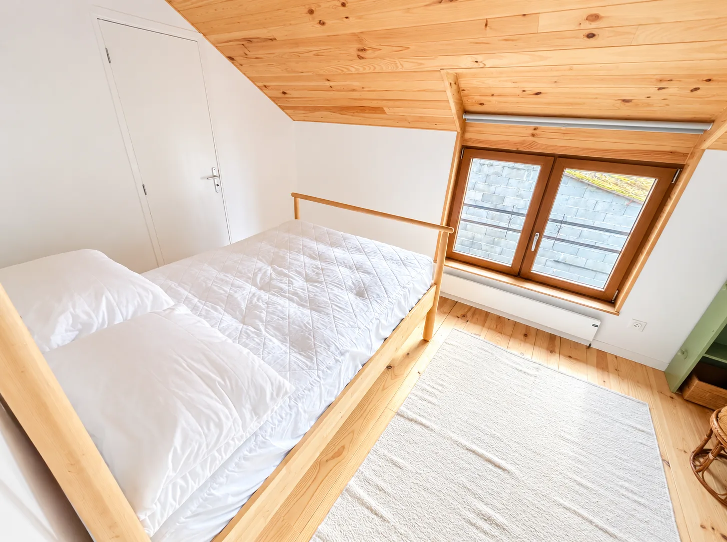 Chambre sous une charpente en bois à Éco-Parc